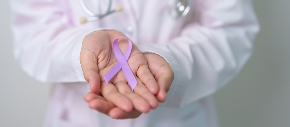 Doctor holding purple ribbon to symbolize lupus awareness.