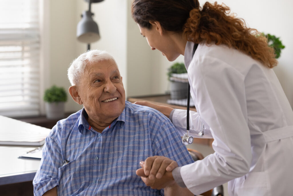 Doctor holding hand of old gentleman with Alzheimer's as she explains infusion therapy options.